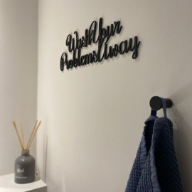 Vægdekoration med citatet "Wash Your Problems Away" i sort mat akryl, 31 cm lang og 10 cm høj.